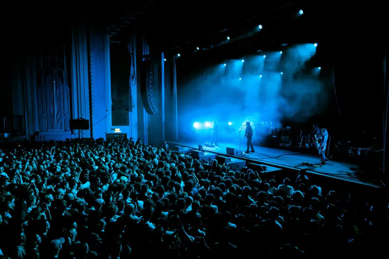 Troxy's main room, full, from the side: the art deco wall, the JBL hang and the stage under blue light